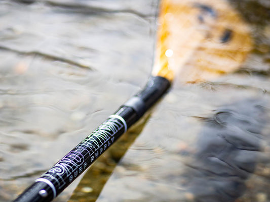 a SUP paddle breaking the waters surface