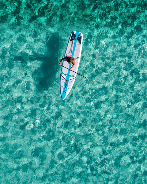 an aerial image of a paddle board on a clear ocean