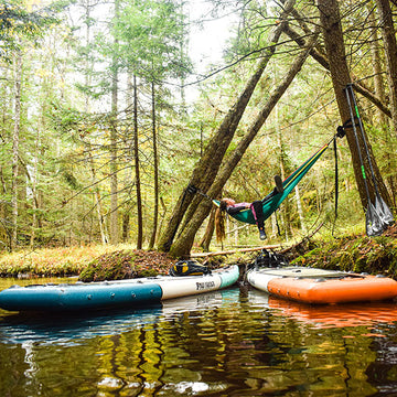 Lying in a hammock by a lake with two paddleboards in the water