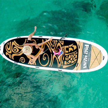 Farther and son fishing from a giant paddleboard on the ocean