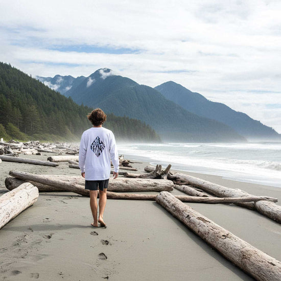 Person standing on a beach with mountains in the background