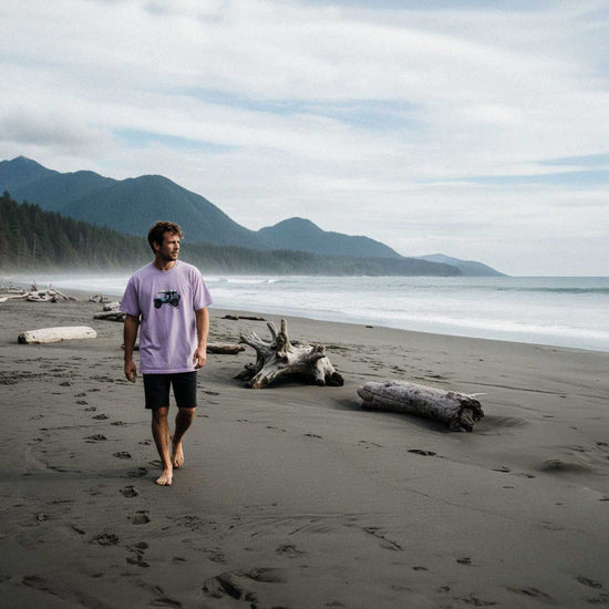 Man walking on a beach with mountains and ocean in the background